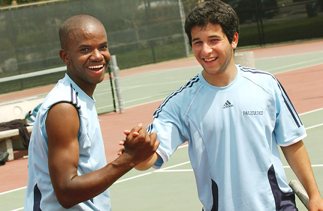 Stephen Surjue (left) shakes hands with partner Sepehr Safii after they swept their three sets at No. 1 doubles for the Dolphins.