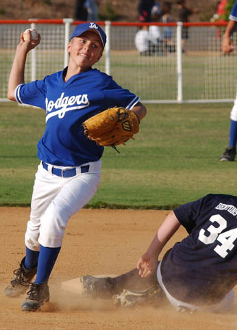 Dodger second baseman Chris Aronson (left) steps off second base and tries to turn a double play during Tuesday's Bronco Division playoff game against the Indians at the Palisades Recreation Center's Field of Dreams complex. The Indians won, 13-10, and advanced to meet the Red Sox for the championship.