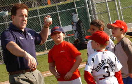 Jake Steinfeld (left) shows Palisades Pony Baseball Association players the art of throwing a fastball at the Rec CenterÃÂ½s Field of Dreams. Steinfeld will throw the first pitch on Opening Day March 20.