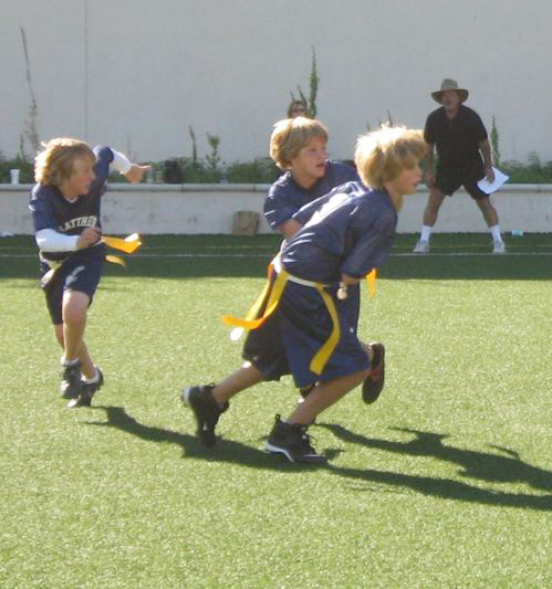 St. Matthew's quarterback Charlie Porter hands the ball off to Lawrence Kondra on a sweep against Calvary Christian. Nick Lenard (far left) trails the play.
