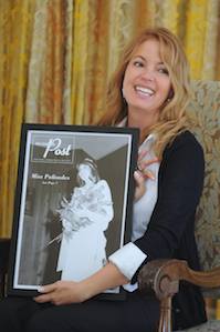 Lakers Executive VP Jeanie Buss holds a framed picture of herself after she was named Miss Palisades in 1979. Buss spoke at last Friday's annual Chamber Breakfast at Riviera Country Club.
