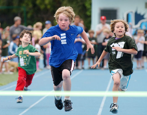 Three young Paliasadians push themselves to the limit in the seven- and eight-year old, 50-meter event. Justin Becker (center) won with a record-time of 7.1 seconds.      Rich Schmitt/Staff Photographer
